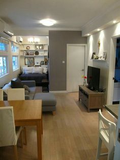 a living room filled with furniture and a flat screen tv sitting on top of a wooden table