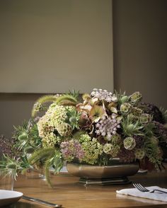 the table is set with flowers and silverware