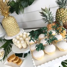 pineapples, cupcakes and other dessert items on a table