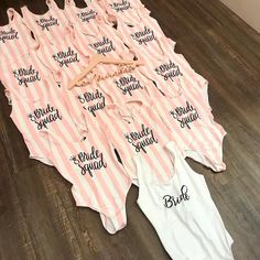 pink and white striped onesuits with bride squad written on them