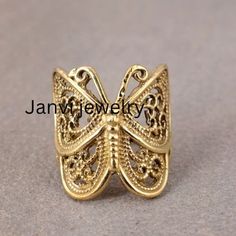 Women Butterfly Ring,Gold Butterfly Ring, Filigree Butterfly Ring, Statement Ring, Handmade Ring, Butterfly Jewelry, Large Butterfly Ring Gemstone: Na Jewelery Category:- Handmade Ring Metal:- Brass -- T H E * Q U A L I T Y We buy raw gemstones directly from miners and then get them cut and polished at our workshop , Therefore saving some bucks (additional added fees and markups) avoiding a middle man and making sure of the authenticity of the gems. And we use top quality materials that are water safe (ideally) However it is highly recommended to avoid water since doing so will prolong the durability and quality of your jewelry. Also, we recommend avoiding contact with chemicals such as bleach, perfume and sunscreen because they can damage the material over time which will affect its quali Handmade Gold Butterfly Ring, Vintage Gold Butterfly Ring Gift, Gold Metal Butterfly Ring As Gift, Handmade Vintage Butterfly Ring For Gift, Handmade Vintage Butterfly Ring Gift, Vintage Handmade Butterfly Ring Gift, Handmade Gold Butterfly Ring For Gift, Gold Butterfly Ring, Ring Butterfly