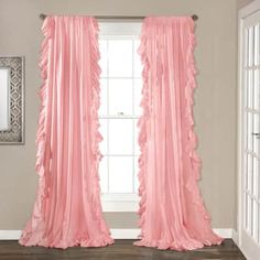 pink ruffled curtains hanging in front of a window