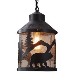 an outdoor hanging light with a bear and tree silhouette on it's glass shade