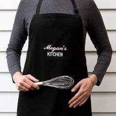 a woman wearing an apron holding a whisk in her hand and the words morgan's kitchen written on it