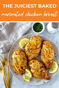 the best baked marinated chicken breast recipe on a plate with lemons and parsley