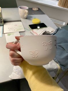 a person holding a white bowl with bows on it