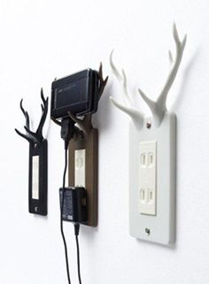 an electrical outlet with two deer antlers on it and one plugged into the wall