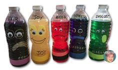 a row of plastic water bottles with faces and words painted on the side, all lined up in different colors