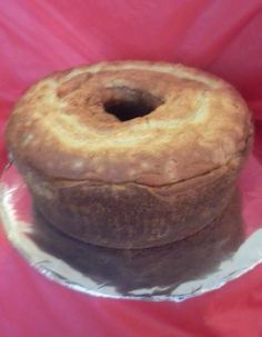 a loaf of bread sitting on top of a pink tablecloth covered plate with silver foil