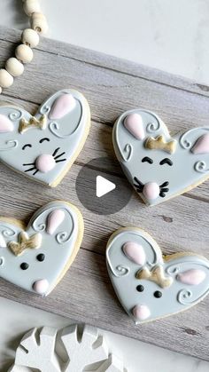 four decorated cookies in the shape of mouses on a wooden board next to a bead necklace