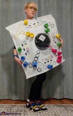 a person holding a board game costume made out of buttons and pegs on it