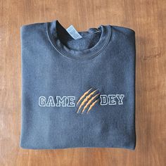 a t - shirt that says game day on the front, and an arrow in the middle