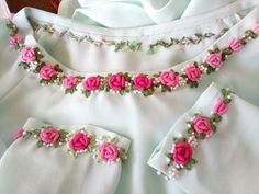 three pieces of white cloth with pink flowers on them