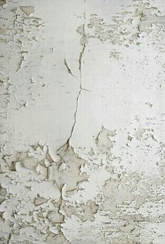 an old white wall with peeling paint and chipped paint on it's surface