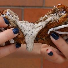 two hands holding food that looks like an animal's skull and bones with white stuff on it