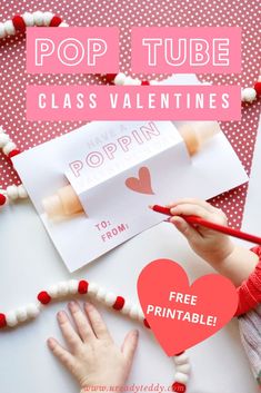 a girl is making valentine's day pop tube cards with her hands on the table