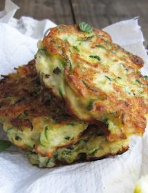 two fritters stacked on top of each other in paper wrappers with green toppings