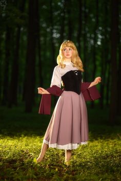 a woman in a dress standing in the grass