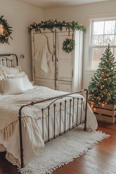 a white bed sitting in a bedroom next to a christmas tree