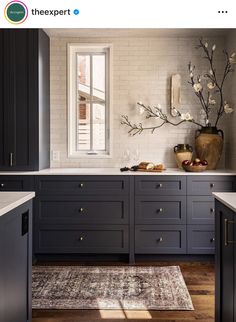 a kitchen with black cabinets and white counter tops