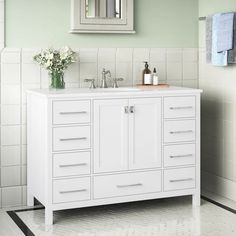 a white bathroom vanity with two sinks and mirrors