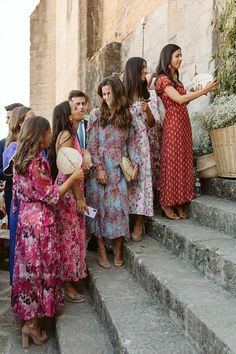 a group of women standing next to each other on the side of a set of stairs