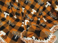 an orange and black checkered blanket with the texas logo on it's side