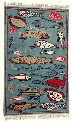 a blue rug with fish on it and fringes hanging from the bottom, in front of