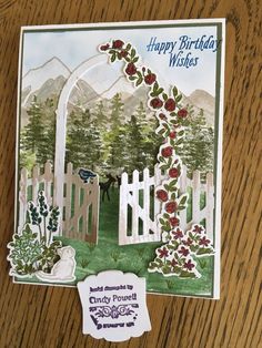 a card with a gate and flowers on it