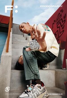 a man sitting on the steps with his hand up to his face and wearing sneakers