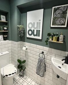 a white toilet sitting in a bathroom next to a sink and a green painted wall