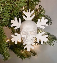 a skull and snowflake ornament hanging from a christmas tree