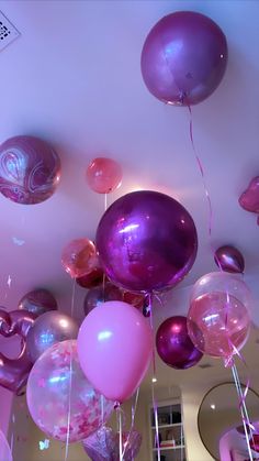 purple and pink balloons are floating in the air