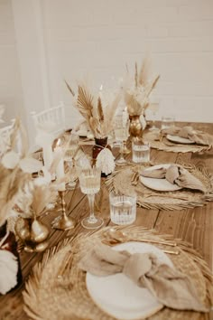 a wooden table topped with plates and glasses