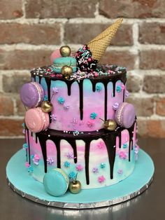 a multi layer cake decorated with ice cream, sprinkles and chocolate icing