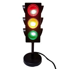 a traffic light that is red, green and yellow with a cord attached to it