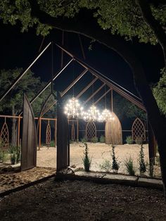 a large wooden structure with chandeliers hanging from it's sides at night