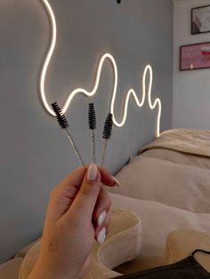 a person holding three toothbrushes in front of a neon sign that says love