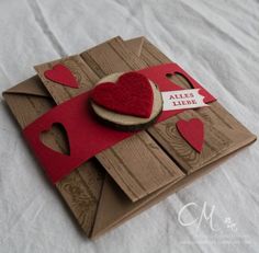 a card made out of cardboard with a red felt heart on the front and two hearts on the back