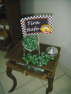 there is a small table with candy on it and a sign that says tira bafo