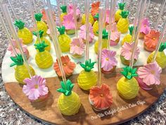 pineapple cupcakes with pink and yellow frosting on a wooden platter