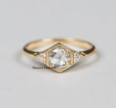 a gold ring with an octagonal cut diamond surrounded by small white diamonds on the sides