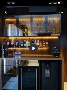 an image of a home bar with liquor bottles on the shelves and lights above it