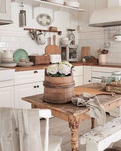 a wooden table sitting in a kitchen next to a stove top oven