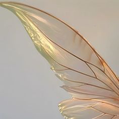 a white and gold feather floating in the air