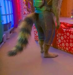 a man dressed as a furry animal standing in front of presents