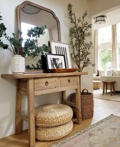 a wooden table topped with a mirror next to a potted plant on top of a hard wood floor