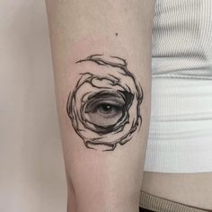 a black and white photo of an eye in a hole on the left inner arm