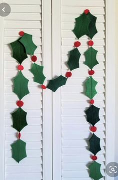 a door decorated with holly leaves and poinsettis hanging on the side of it