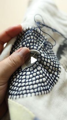 someone is stitching something on the fabric with their fingers and thumbnails in order to make it look like they are sewing